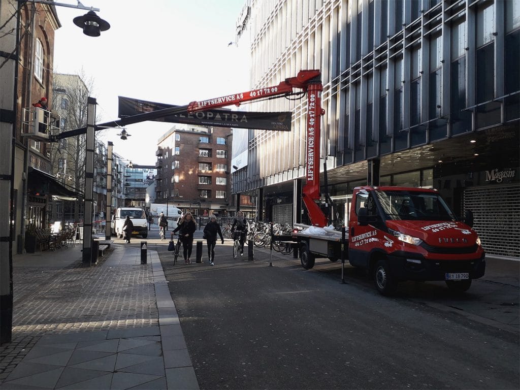 Liftservice monterer banner på bygning
